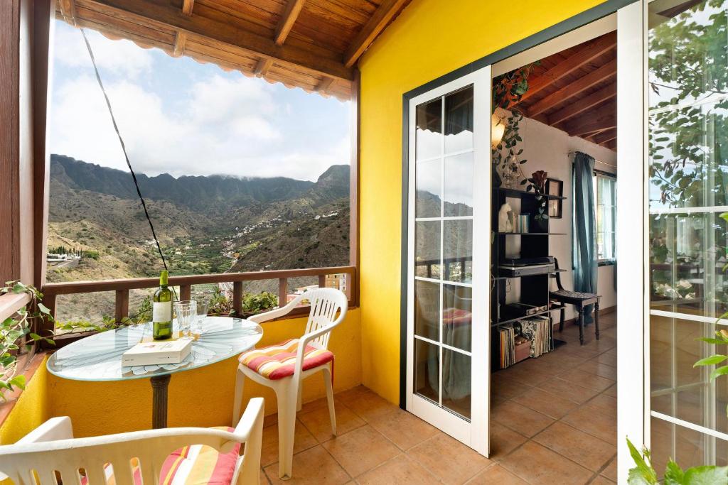 a house with a balcony with a table and chairs at Casa Claudia in Hermigua
