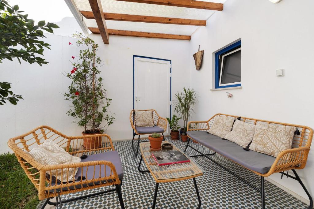 a patio with two wicker chairs and a couch at Casa das Cantonas Valada in Valada
