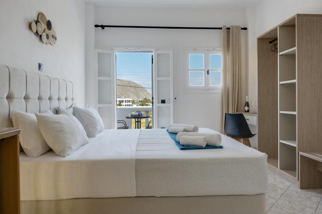 a white bedroom with a large white bed with white pillows at Seaview Double Room Private Jacuzzi in Santorini