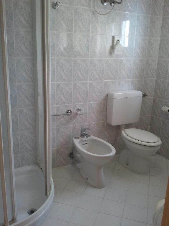 a bathroom with a toilet and a shower at Hotel Berna in Eraclea Mare
