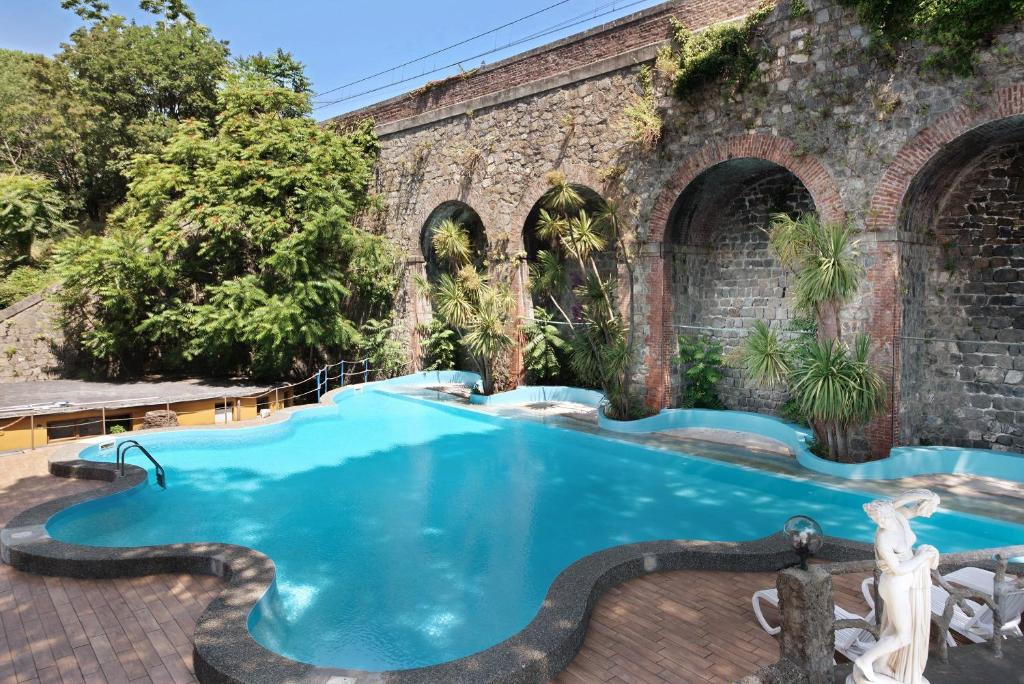 a swimming pool in front of a brick building at Appartamento Bilocale Moneglia 32 in Moneglia