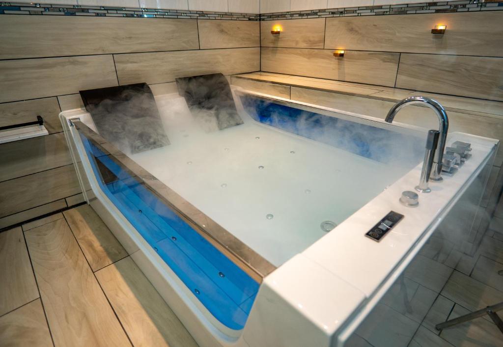 a bath tub with a faucet in a bathroom at Spawo mit Sauna und Whirpool in Pfullendorf