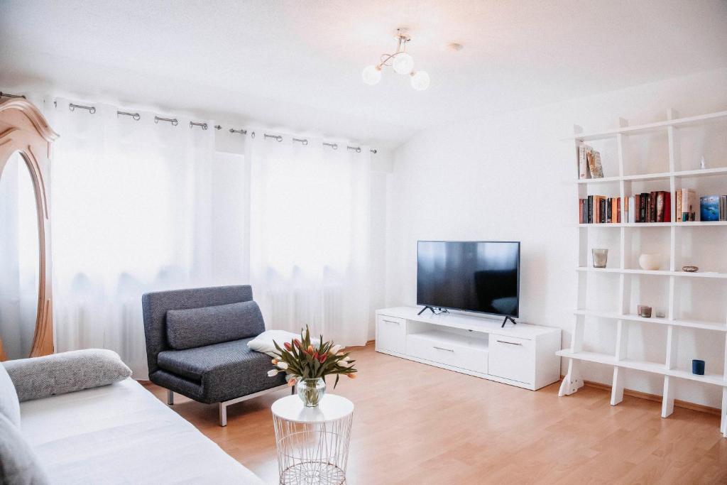 a living room with a tv and a couch and a chair at Auszeit am See in Moos