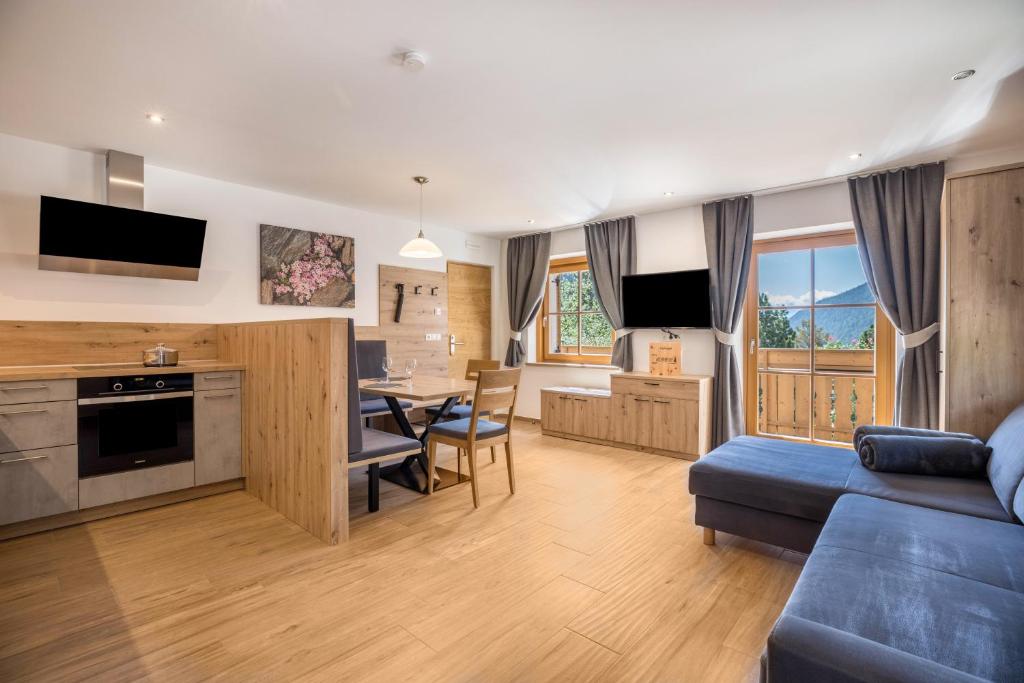 a living room with a blue couch and a table at Lechnerhof Murmeltier in Valles