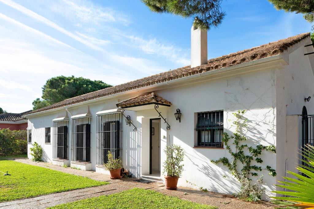 a white house with a green yard at El Mirlito in Roche