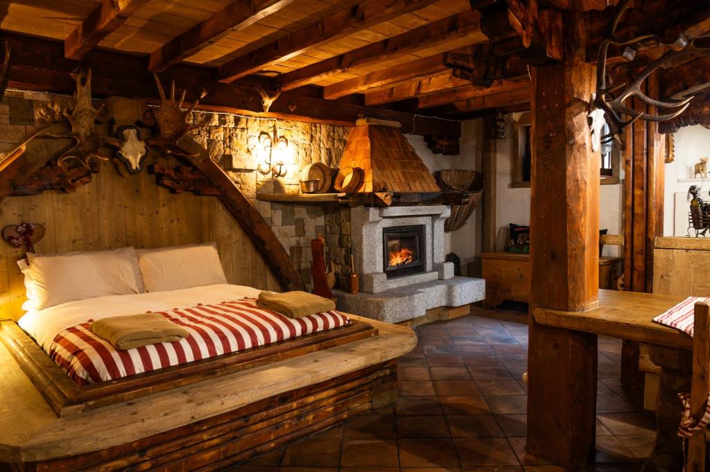 a bedroom with a bed in a room with a fireplace at Alfio's Alpen Suite in Roncone