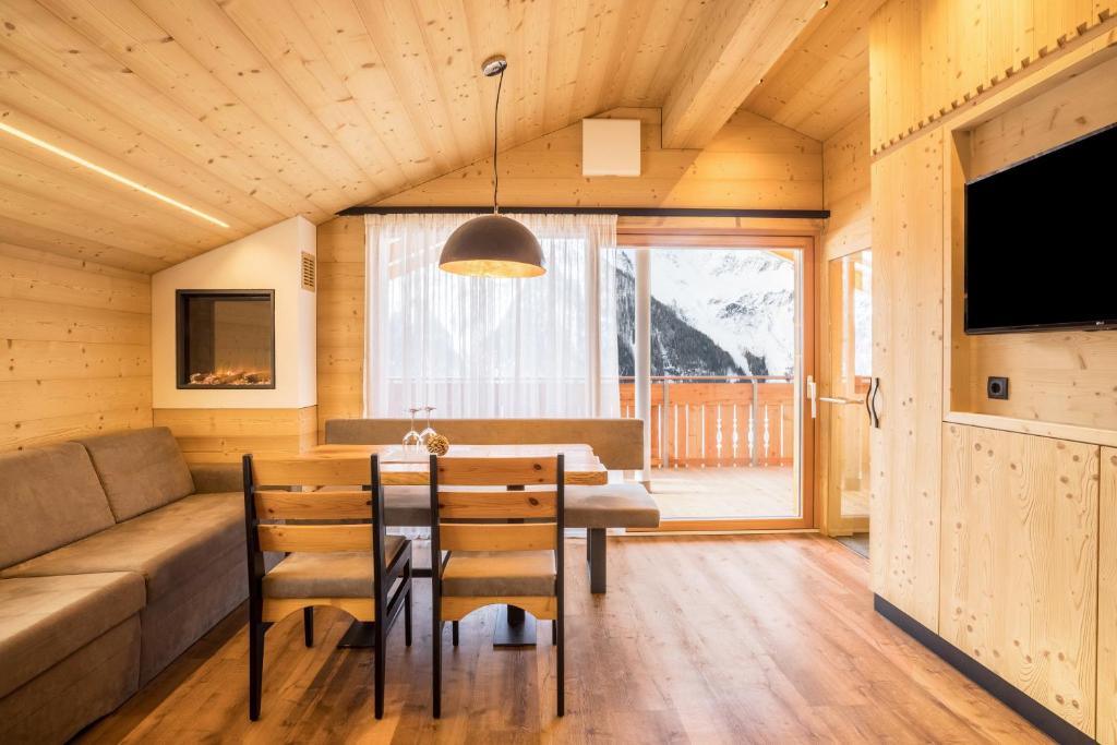 a dining room with a table and a couch at Chalets Reisnock - Hochgruberhof in Selva dei Molini