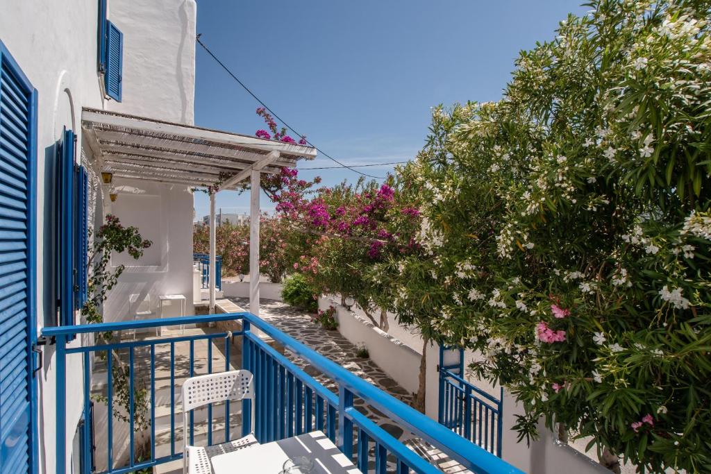 a balcony with blue and white buildings and flowers at Livadia Seaside Studios 10 in Parikia