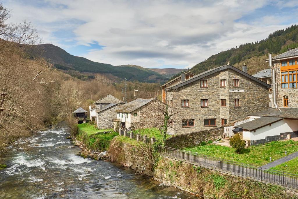 a river in a village next to some buildings at Valle del Ibias - Primero Derecha in Cecos