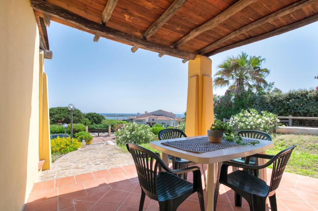a table and chairs on a patio with a view at Villa Giada in Stintino
