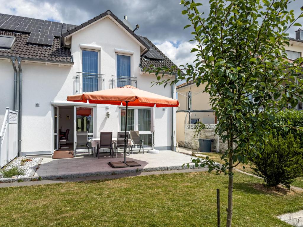 a house with a patio and an orange umbrella at Storchennest in Markdorf