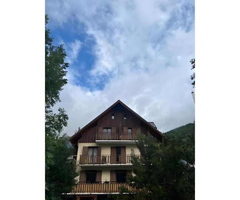 a house with a balcony and a blue sky at Chalet Moulinot in Valloire