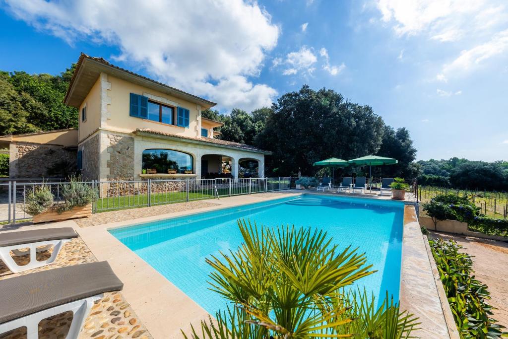 a swimming pool in front of a house at Es Pujols in Artá