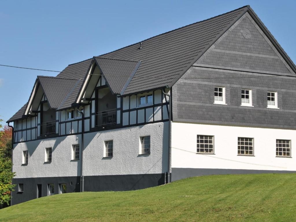 a large gray and white building with a black roof at Ferienwohnungen Übern Hof in Schmallenberg