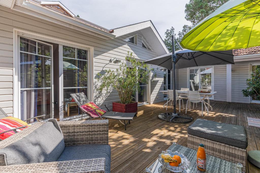 a patio with an umbrella and a table and chairs at Maison Le Moulleau in Arcachon