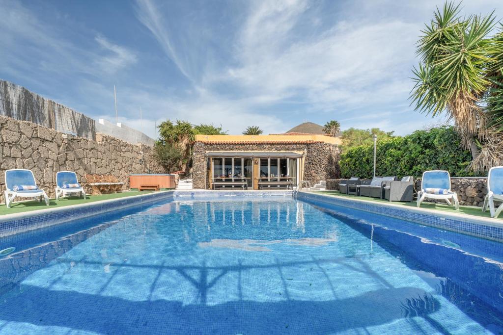 a swimming pool with chairs and a house at Finca Toledo in San Miguel de Abona