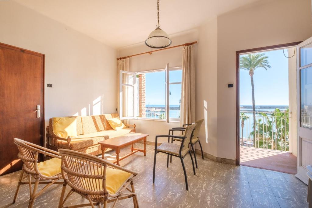 a living room with a couch and a table and chairs at Apartamento las Palmeras 4 in Benicarló