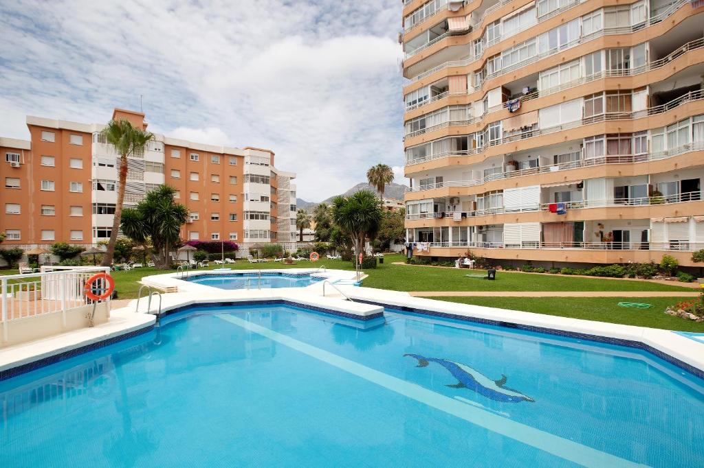 a swimming pool with a dolphin in the middle of a building at Apartamento Saltillo Alto in Torremolinos