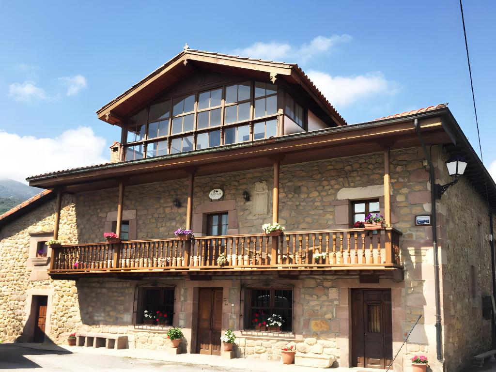 a large stone building with a balcony on it at Posada Rural La Capellanía in Celis