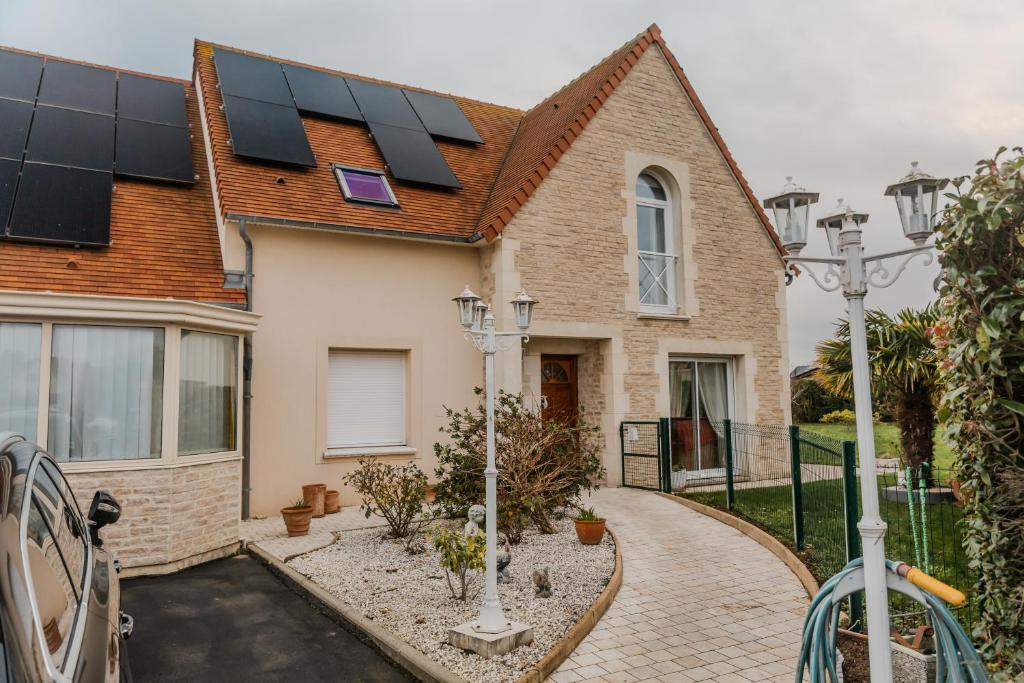 a house with solar panels on the roof at Courseulles Comme À La Maison in Courseulles-sur-Mer