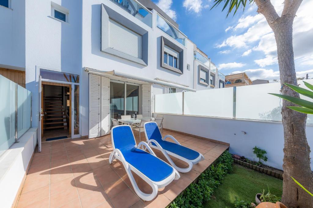 two lounge chairs on a patio in front of a house at Can Bennasar in Can Picafort
