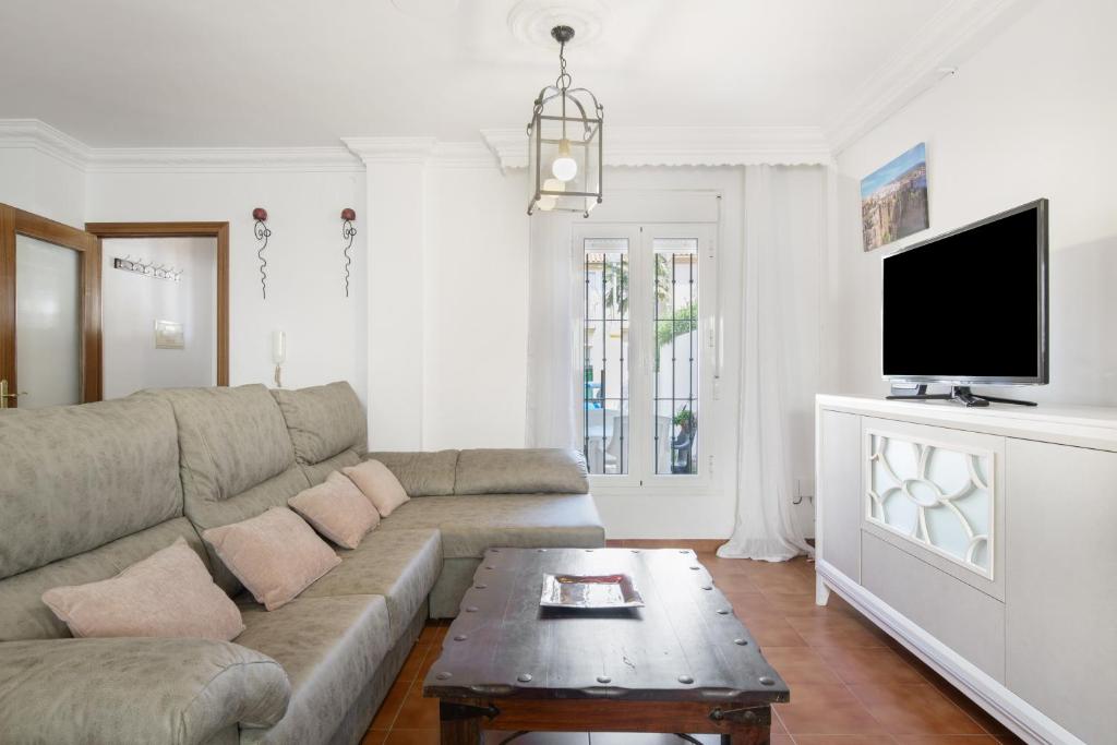 a living room with a couch and a tv at Casa Cherie con piscina privada in Ronda