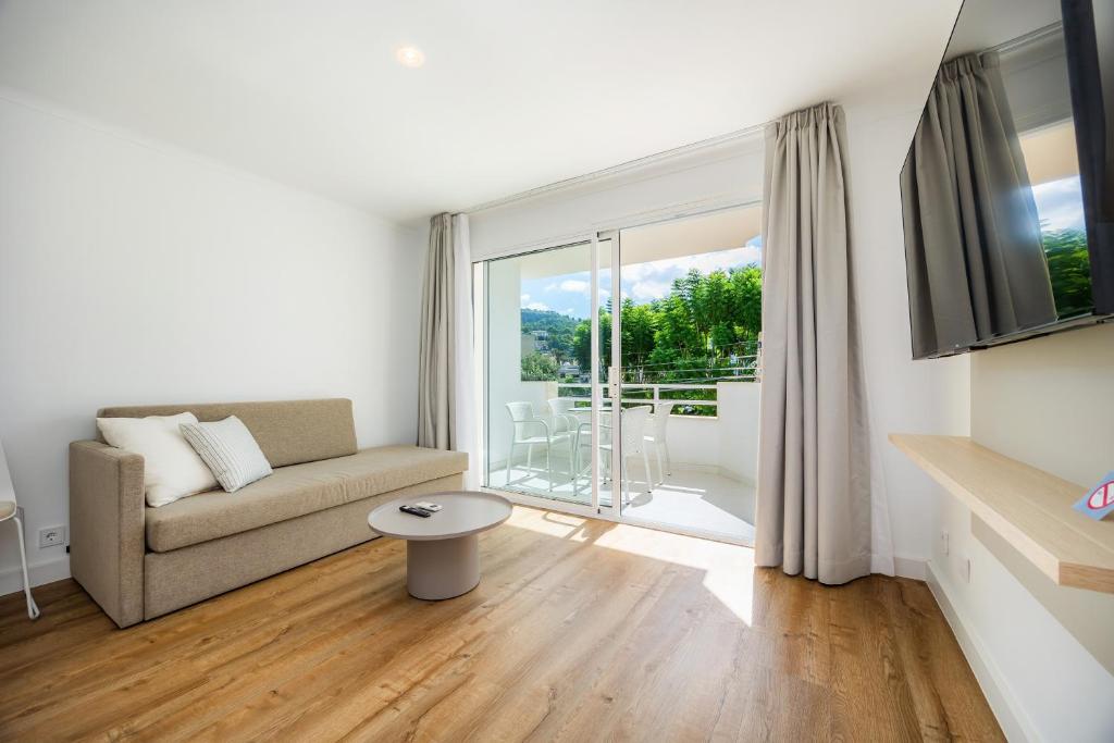 a living room with a couch and a large window at Apartament Massanet 1a in Canyamel