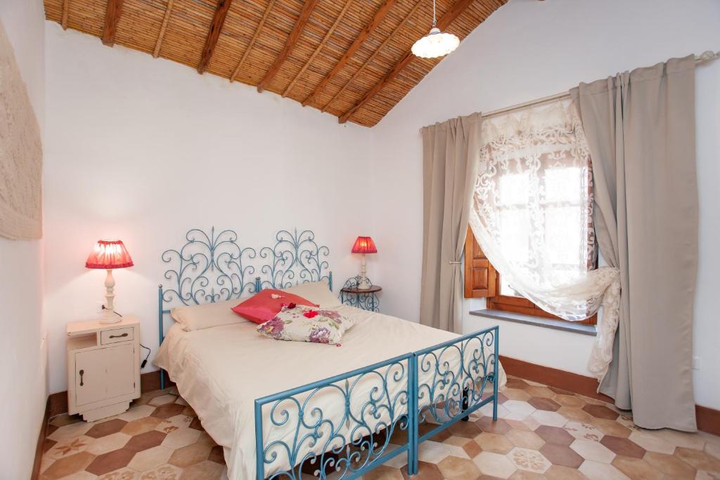 a bedroom with a blue and white bed and a window at Domo Bangone in Orosei