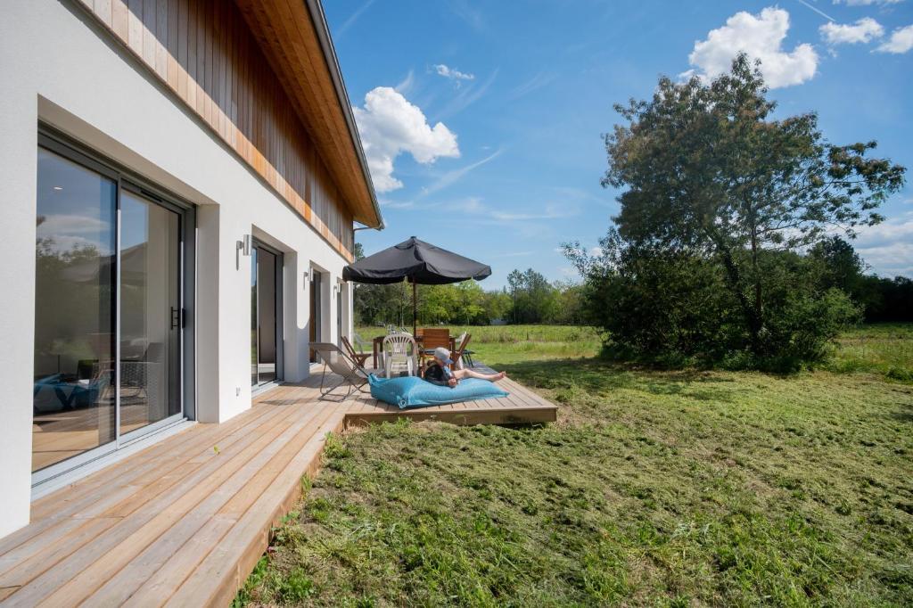 a woman laying on a deck next to a house at Villa Surf and Golf in Messanges