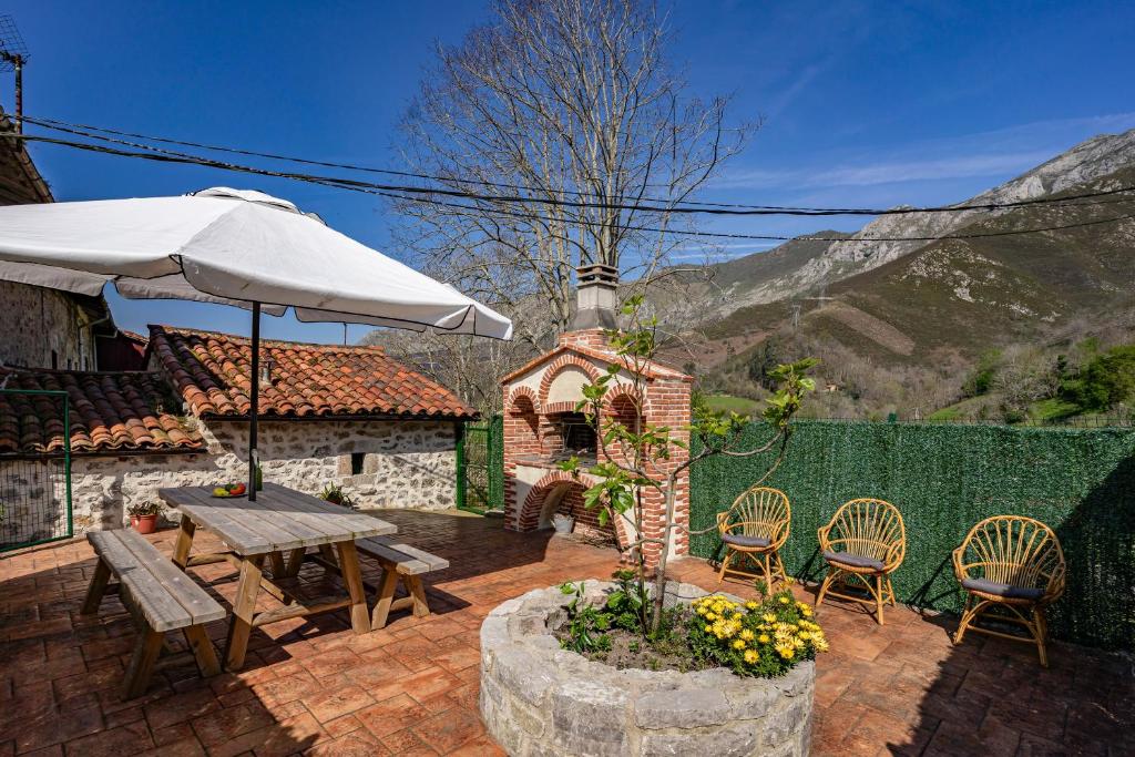 a patio with a table and chairs and an umbrella at La Breval in Alles