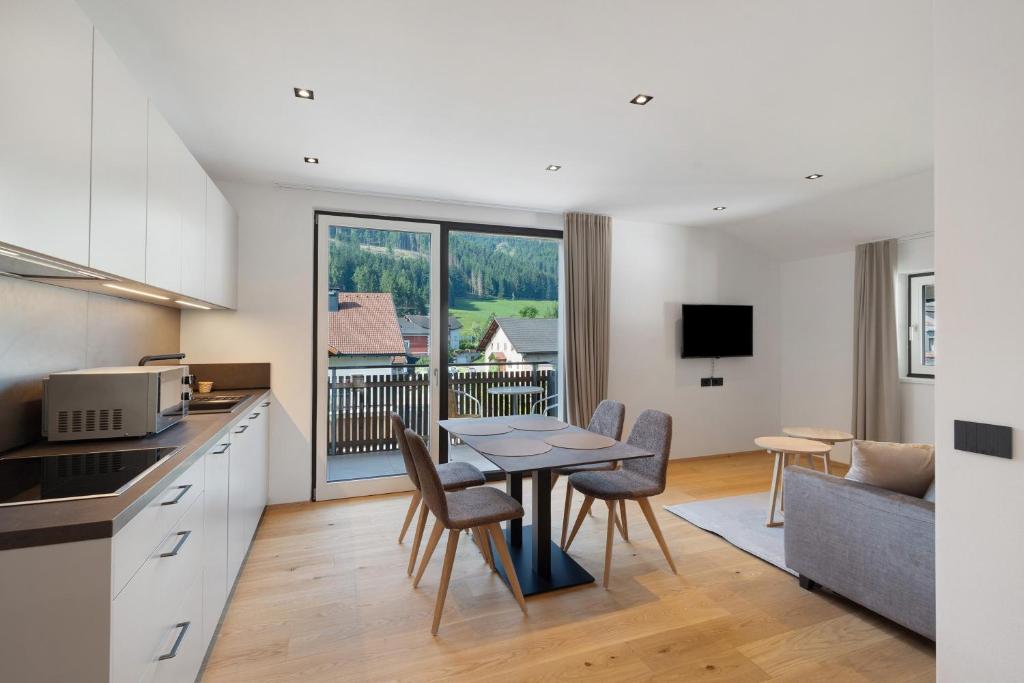 a kitchen and living room with a table and chairs at Premium App Hofer Marianna in Villabassa