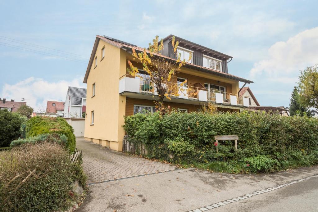 a yellow house with a bench in front of it at Ferienwohnung Steinhilber 1 in Eriskirch