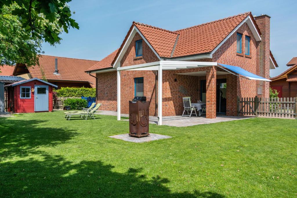 a brick house with a large yard with a gas meter at Haus Hafenblick in Walchum
