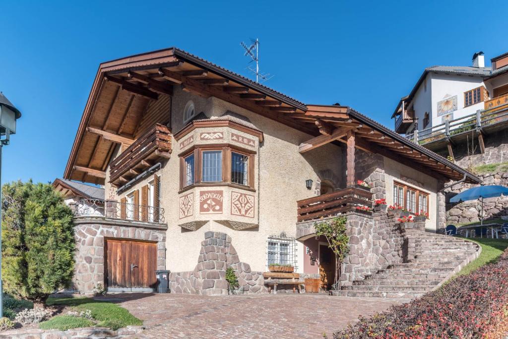a stone house with a wooden door and stairs at Villa Soldanella in Ortisei