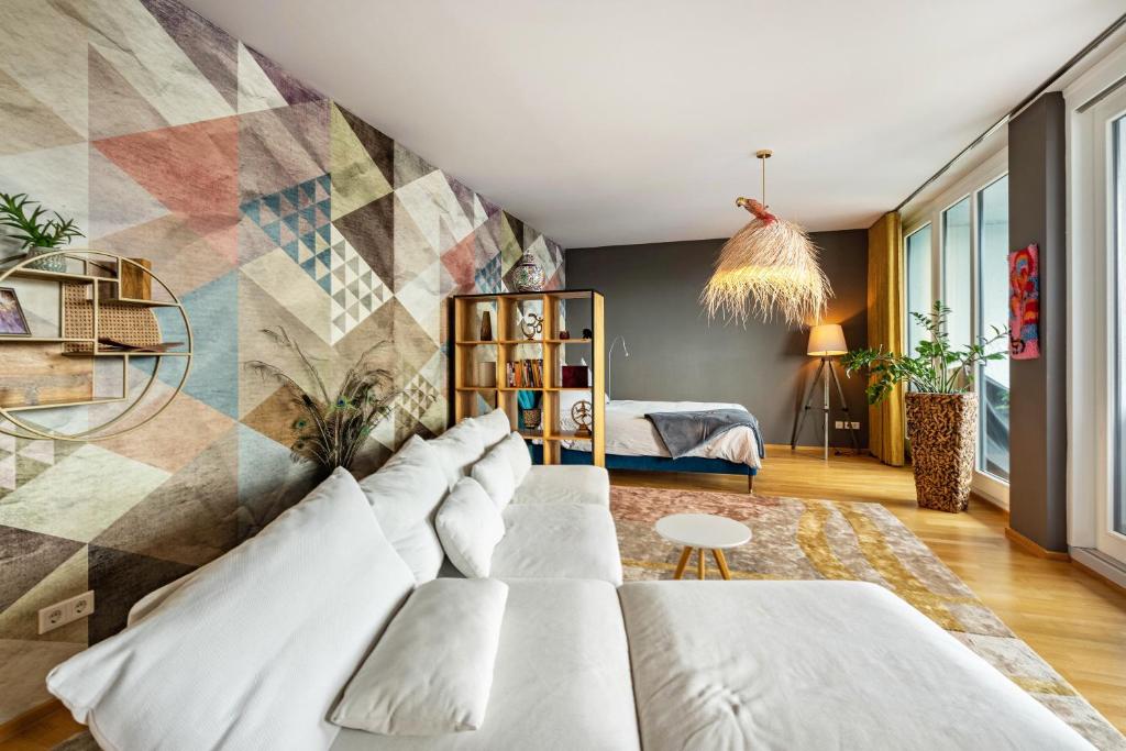 a living room with a white couch and a geometric wall at Studio am Schloßteich in Chemnitz