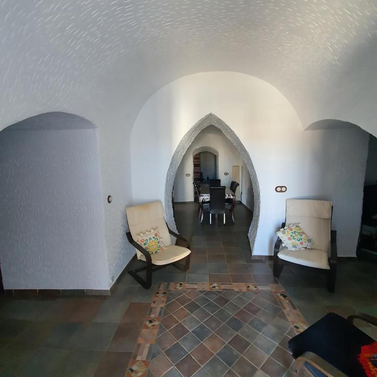 a living room with two chairs and a table at Cueva de Manuel in Guadix