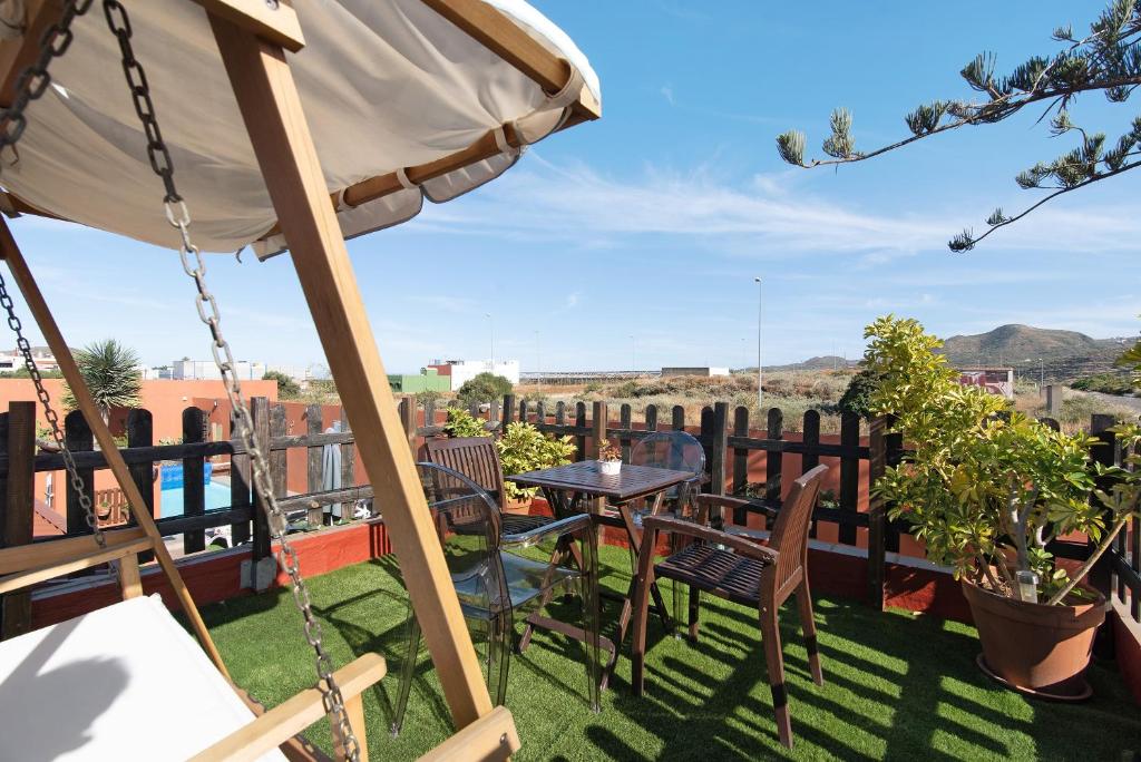 a patio with an umbrella and a table and chairs at Villa La Quinta de Vals in Valsequillo