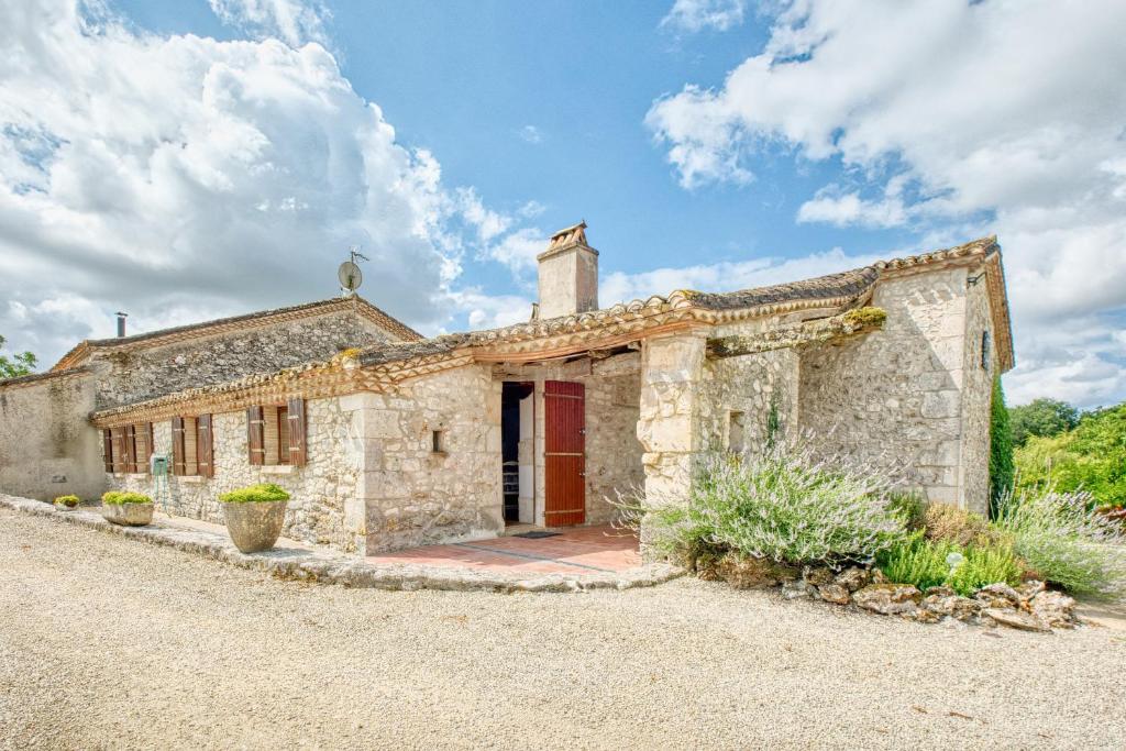 an old stone house with a red door at Le Chai in Razac-dʼEymet
