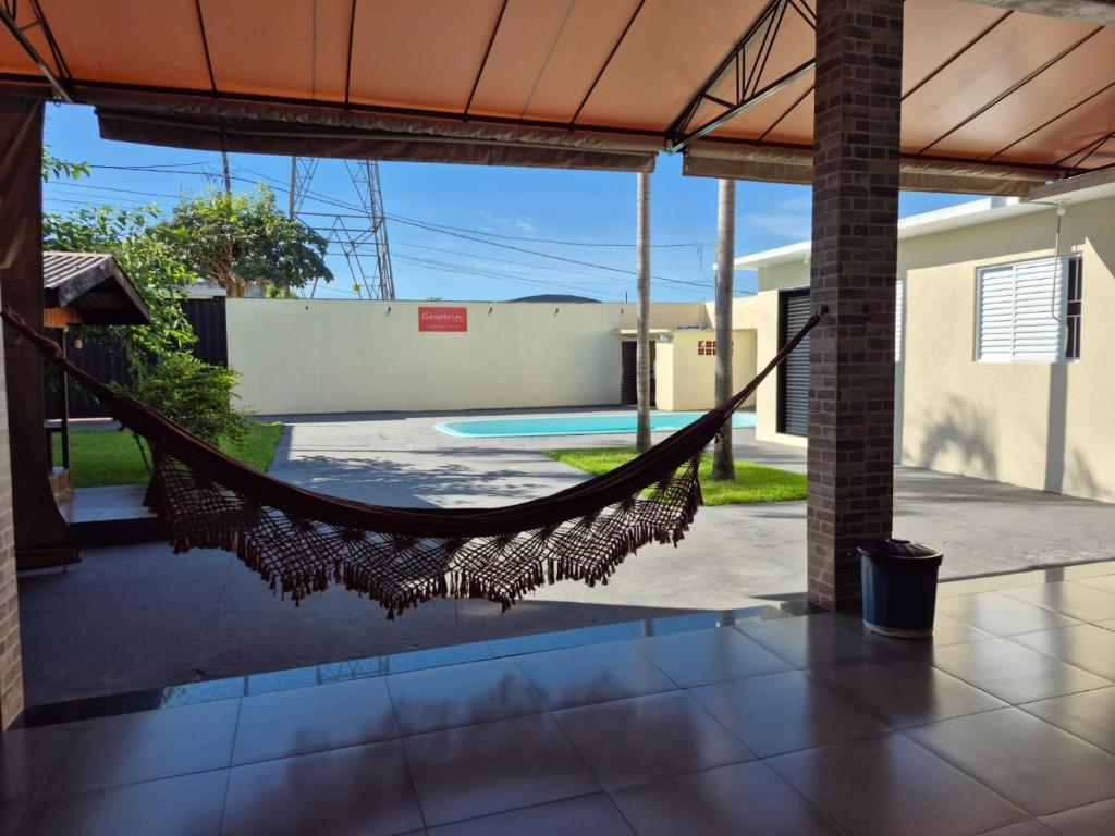 a hammock in the middle of a patio with a pool at Casa com piscina em Maringá in Maringá
