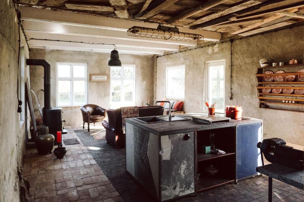 a kitchen with a sink and a living room at Projektraum Obst und Sterne in Rensow