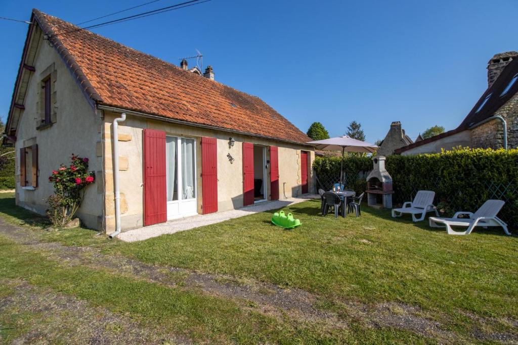 a small house with red doors and a yard at Gite La Salamandre in Saint-André-dʼAllas