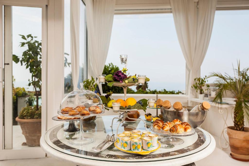 a buffet of food on a table with a window at Tenuta Del Poggio Antico in Ischia