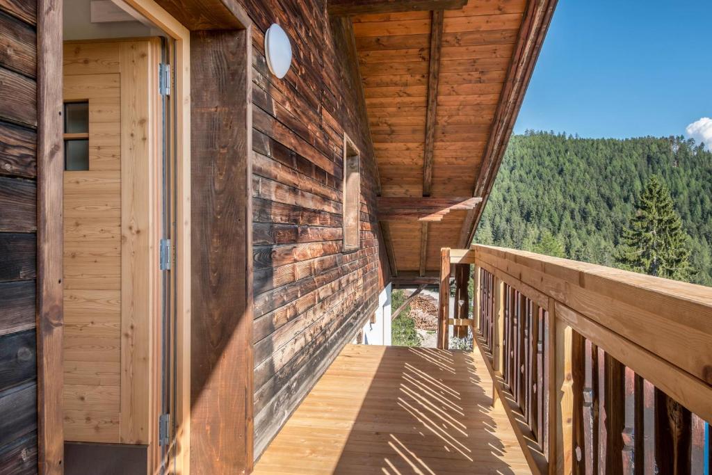 a balcony of a wooden house with a view of the mountains at Nigglhof Apartment Katarina in Redagno