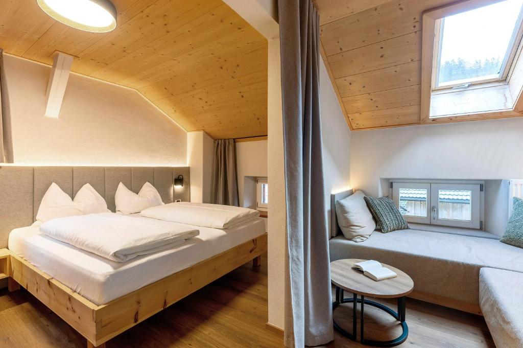 a bedroom with two beds and a couch in a room at Ferienwohnung Lavendel Thalerhof in Ponte Nova