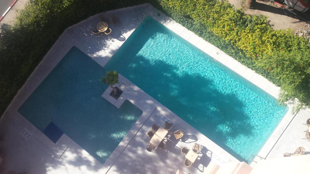 vista sul tetto di una piscina con 2 lettini di Hotel Le Grand Imilchil a Marrakech