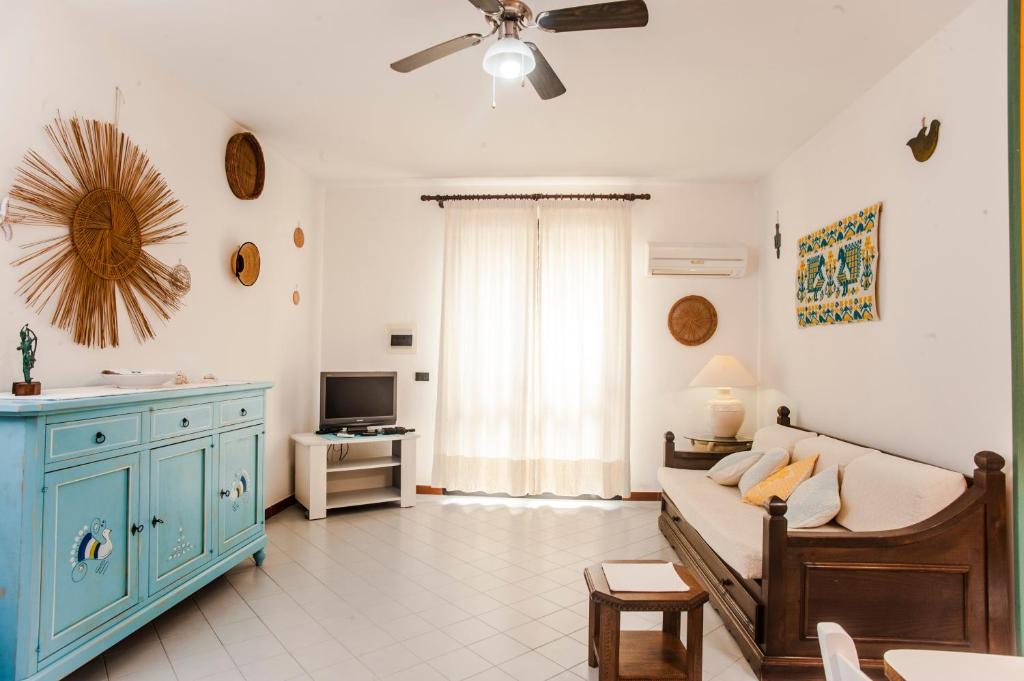 a living room with a couch and a ceiling fan at Piccola casa Marina in Villa San Pietro