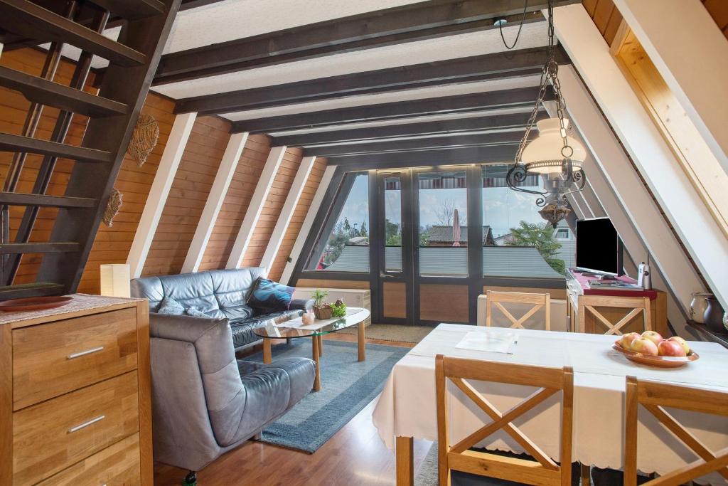 a living room with a couch and a table at Nurdach-Haus Typ 7 in Immenstaad am Bodensee