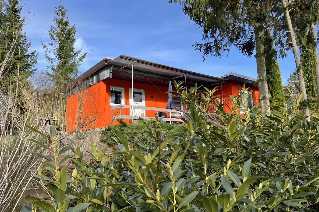 an orange house is seen behind some trees at Ferienhaus 219 in Zadelsdorf