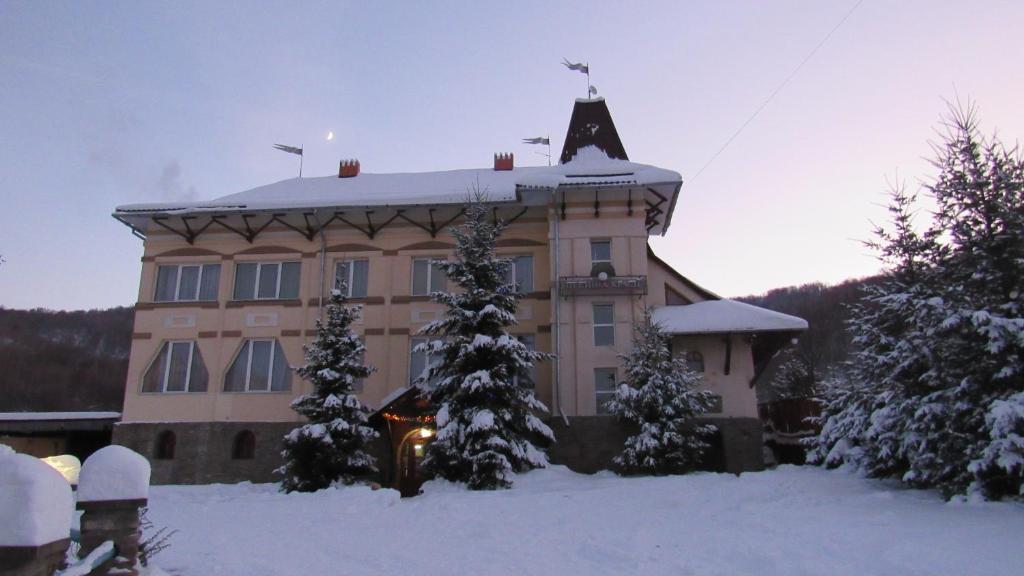 un gran edificio con una cruz en el techo en la nieve en Perlyna Krasiyi, en Vyshka