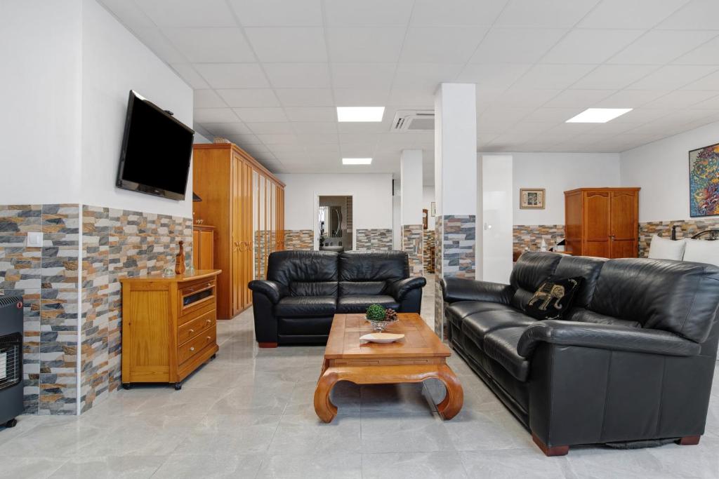 a living room with two leather couches and a coffee table at Loft Los Olivos in Algar